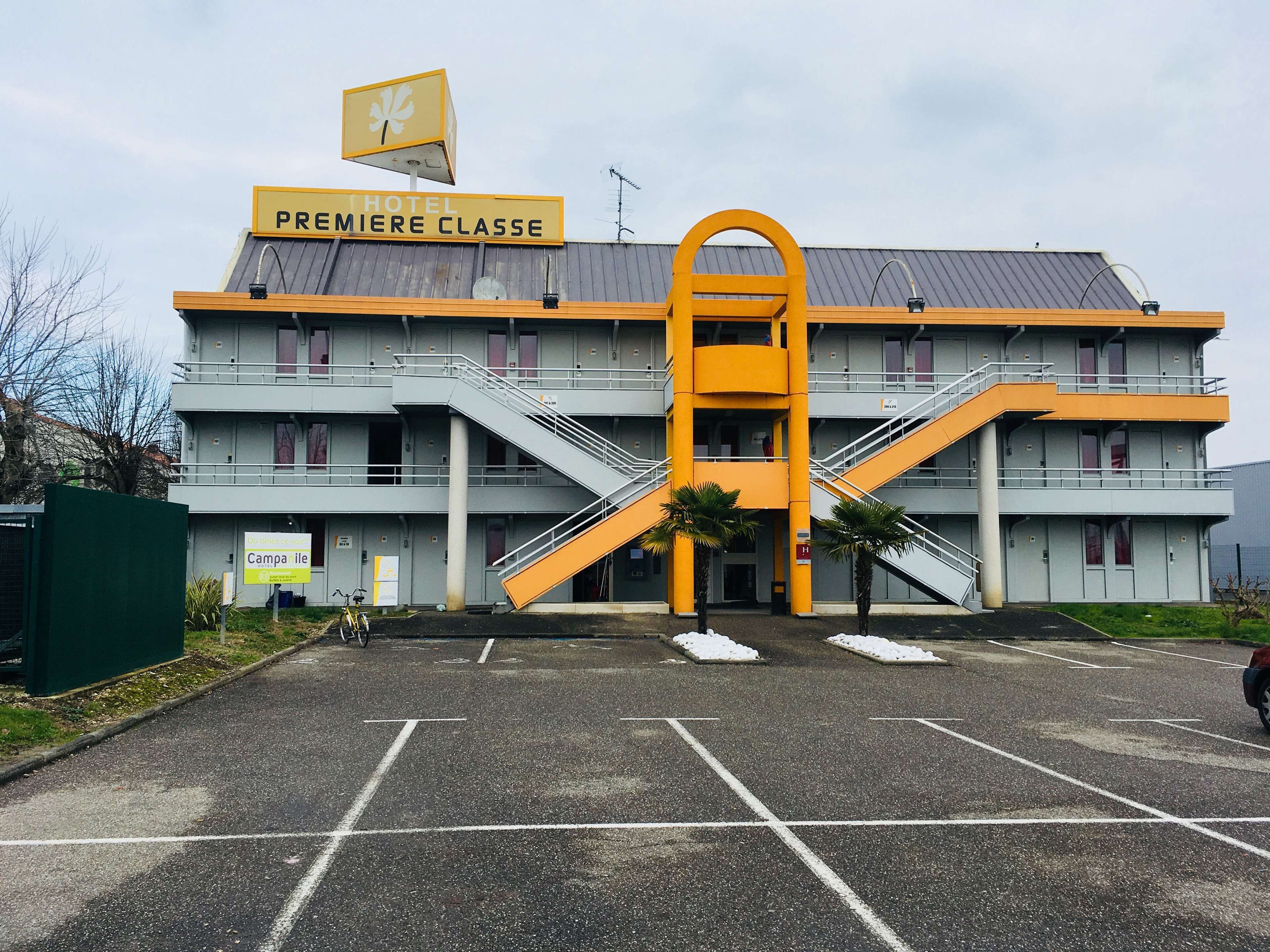 Un hotel de varios pisos con una estructura amarilla destacada en el centro.