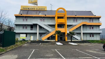 Un hotel de varios pisos con una estructura amarilla destacada en el centro.