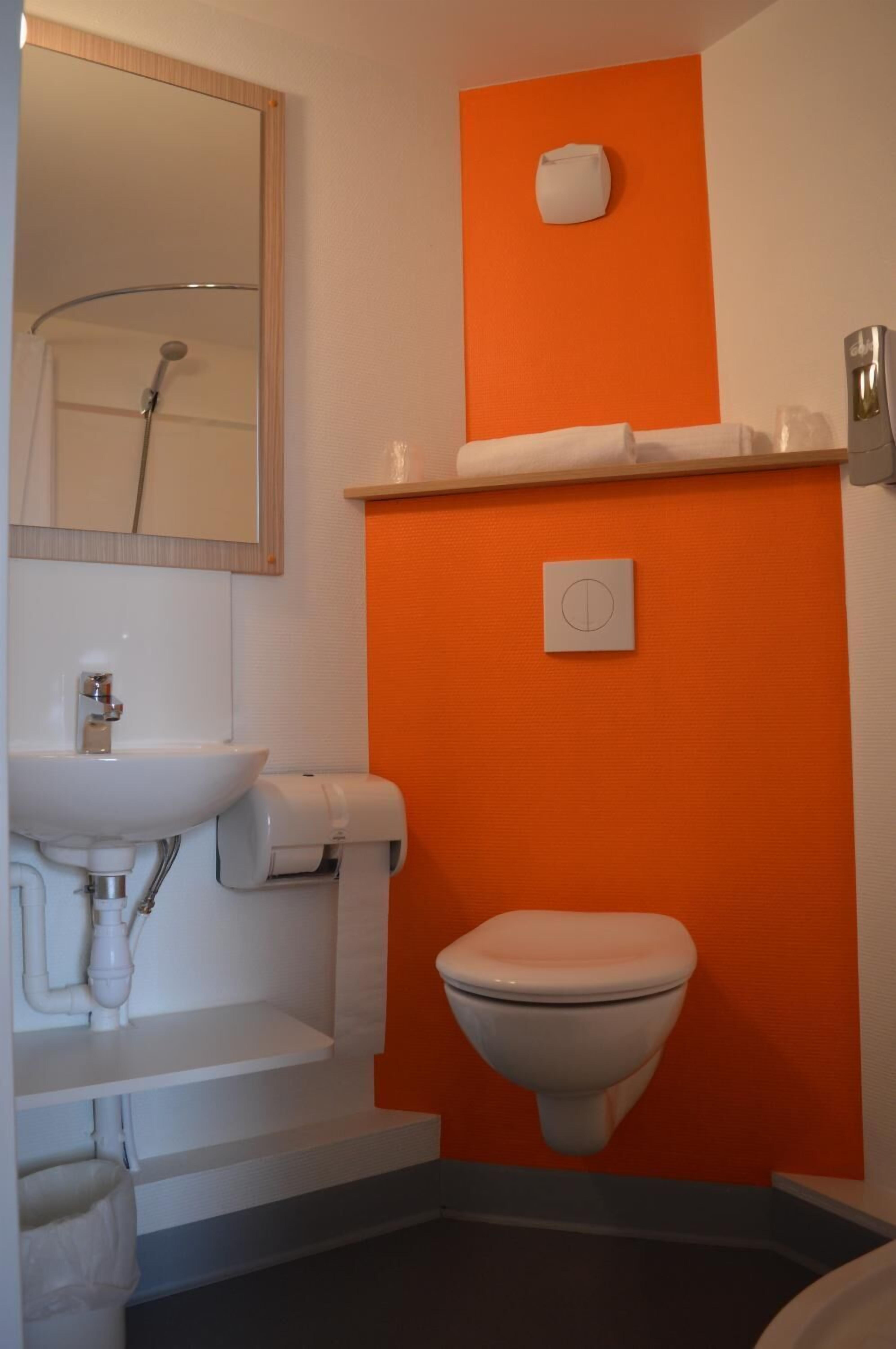 A bathroom with a white sink, toilet, and shower.