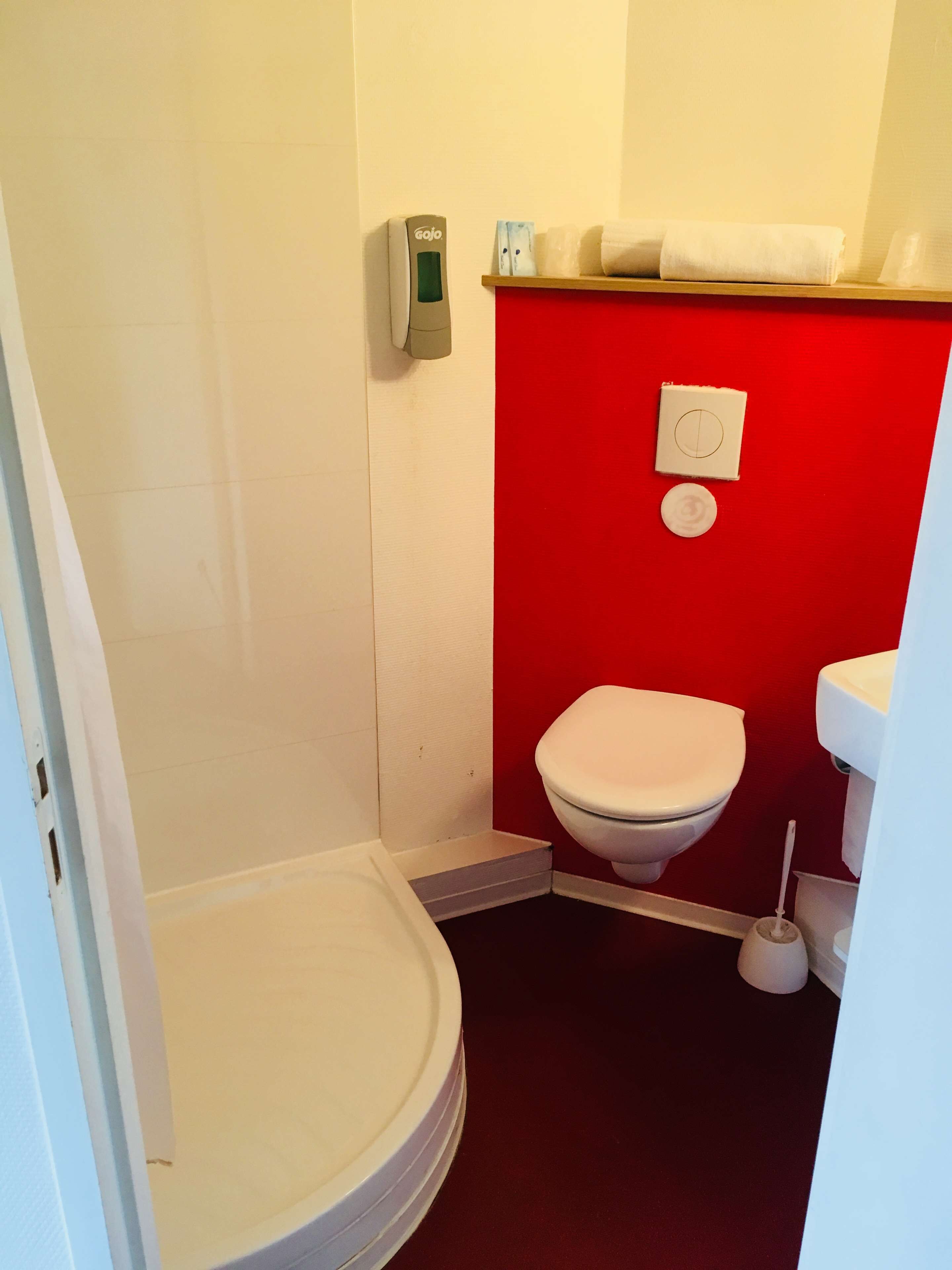 Une petite salle de bain comprenant des toilettes, un bidet et un porte-rouleau de papier toilette.