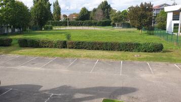 Ein Parkplatz mit einer grünen Hecke und einem Gebäude mit dem Schild "BB Hotel".