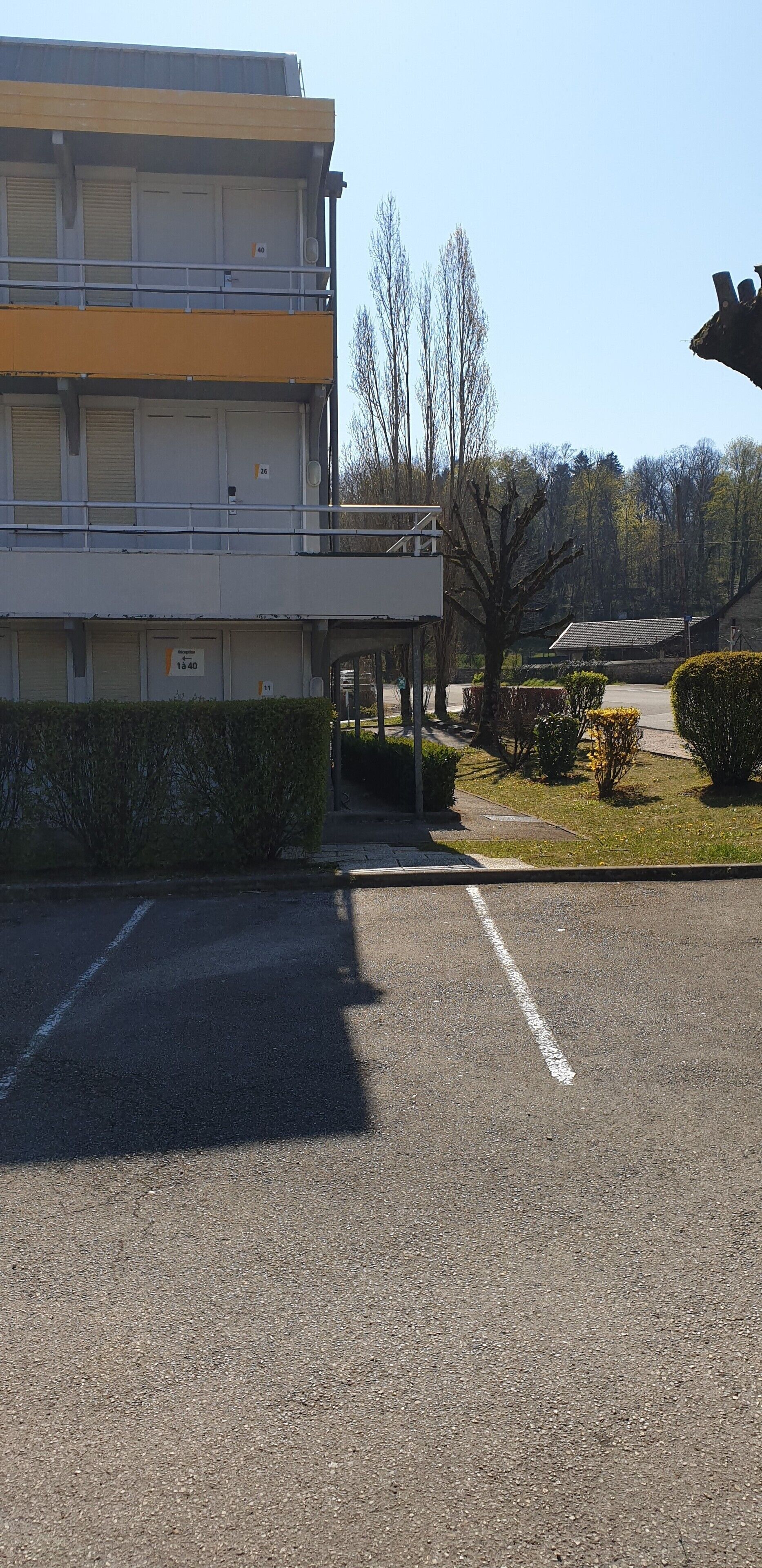 A multi-story building with a parking lot in front.