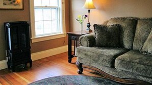 A living room with a sofa, a lamp, a window with a view, and a fireplace. - Wildcat Inn & Tavern (Jackson)