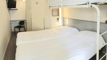 Une chambre avec un lit superposé, un bureau et une chaise, une télévision et un panneau indiquant qu'il est interdit de fumer.