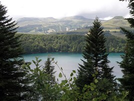 Un lago rodeado de un bosque denso y colinas.