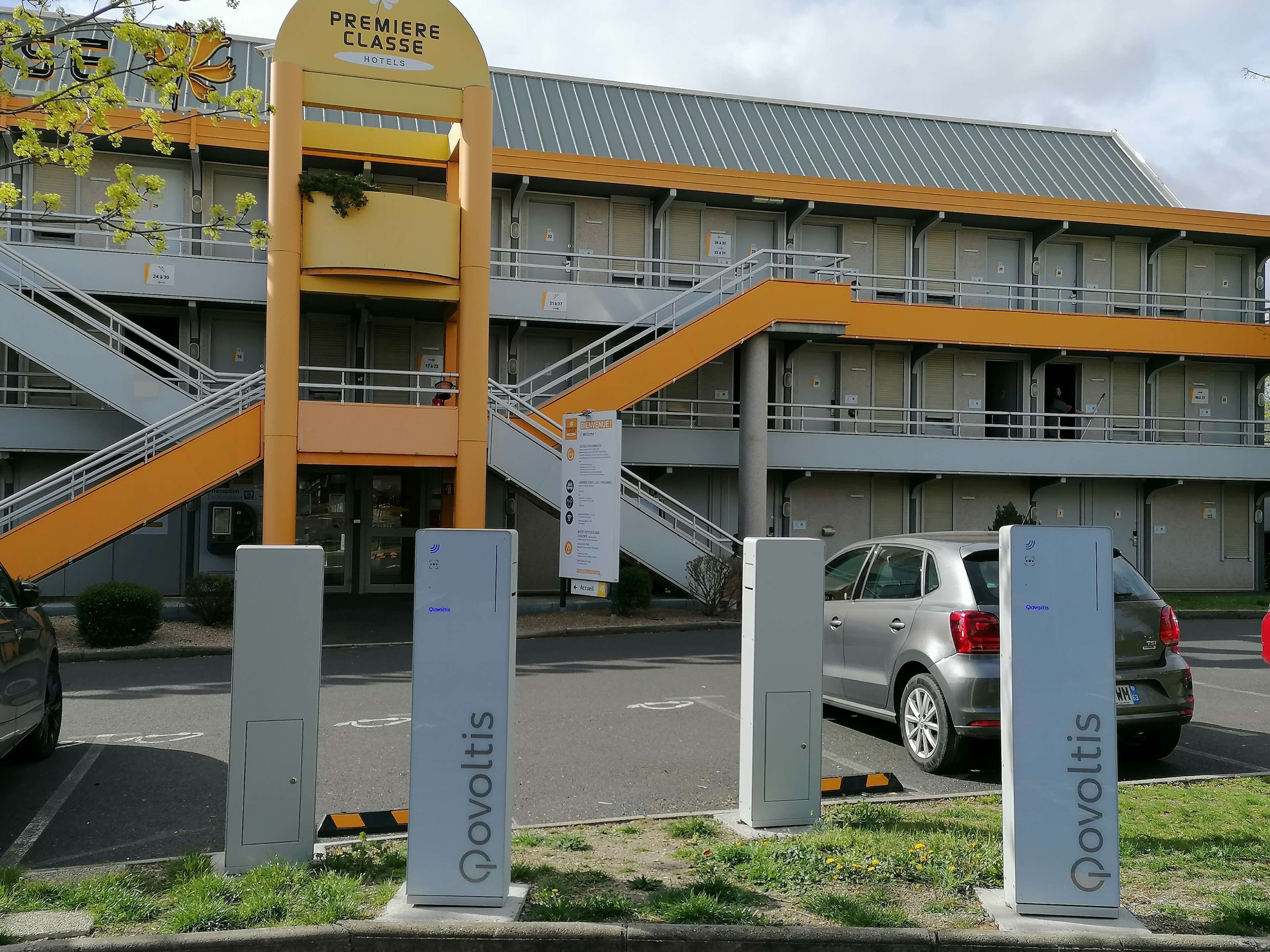 A hotel entrance with a staircase leading to the main building, marked by a sign indicating 'Premiere Classe Hotels'.