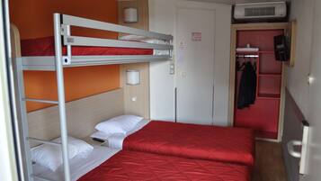 Une chambre avec un lit superposé, une couette rouge, un mur blanc et une porte avec un porte-manteau.