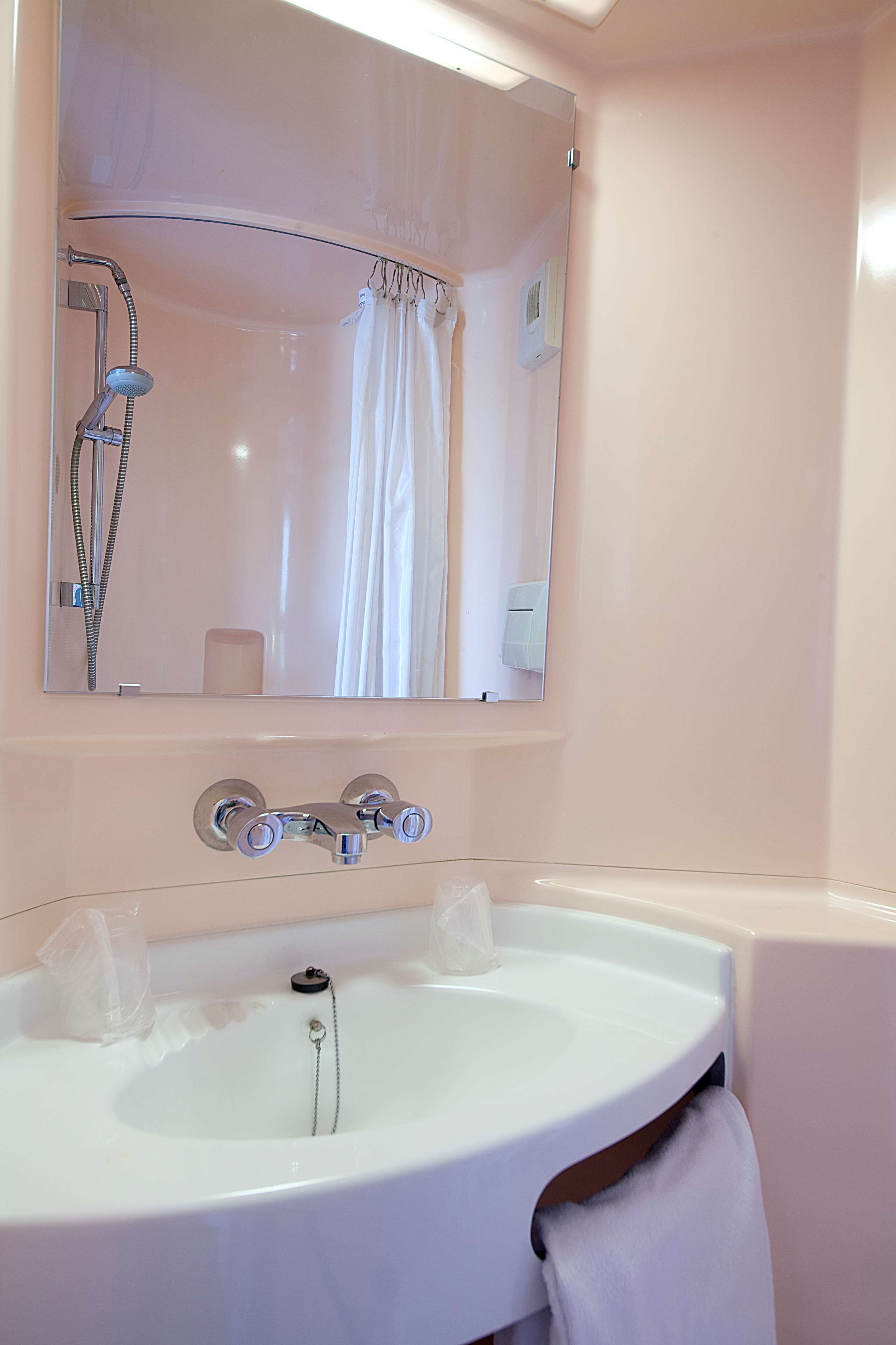 Een douche,  milieuvriendelijk toiletgerief, handdoeken