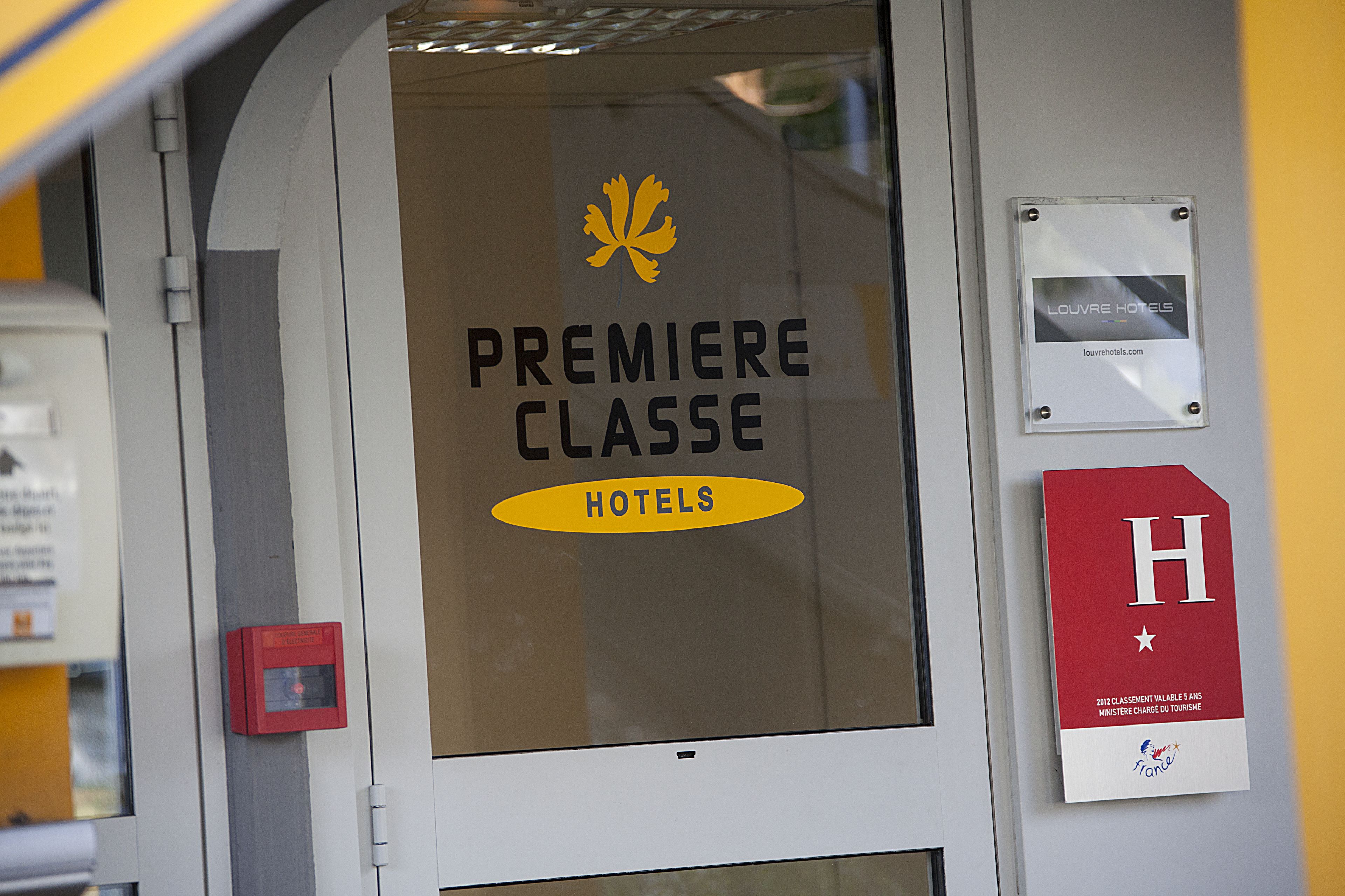 A hotel entrance with a sign reading "PREMIERE CLASSE HOTELS".