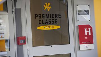 A hotel entrance with a sign reading "PREMIERE CLASSE HOTELS".