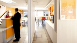 A modern restaurant interior with a reception area, seating, and a counter. - PREMIERE CLASSE CLERMONT FERRAND SUD - Aubière (Aubiere)