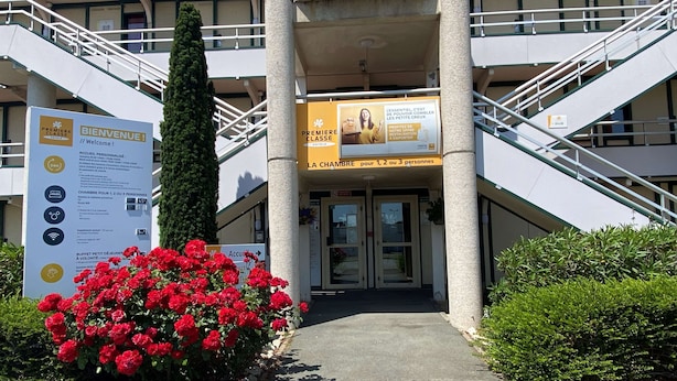 A hotel entrance with a staircase, a welcome sign, and a sign indicating room availability for 1, 2, or 3 people. - Premiere Classe La Rochelle Sud-Angoulins (Angoulins)