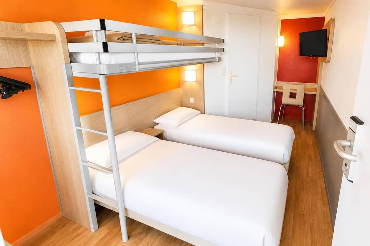 Habitación con literas, escritorio y televisión.