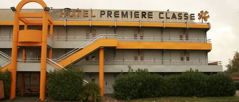 Un hotel con un letrero que dice "HOTEL PREMIERE CLASSE" y una escalera que lleva a la entrada.
