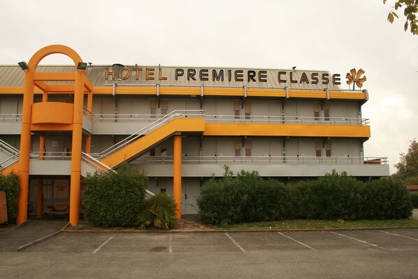 Un hotel con un letrero que dice "HOTEL PREMIERE CLASSE" y una escalera que lleva a la entrada.