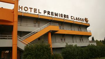 A hotel with a sign reading "HOTEL PREMIERE CLASSE".