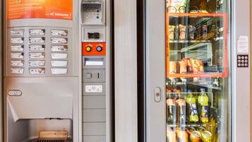 A vending machine with a selection of snacks and beverages, including chips, cookies, and drinks like Coca-Cola and Fanta.