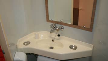 Un baño con un lavabo blanco, un espejo y un perchero para toallas.