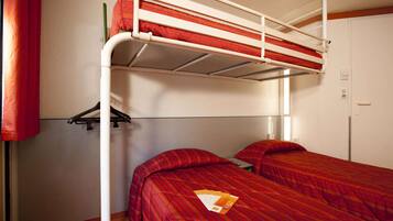 A bunk bed room with two beds, a wardrobe, and a small table with a book.