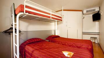 Habitación con literas, una colcha roja, una escalera, un escritorio con una silla y un equipo de aire acondicionado.