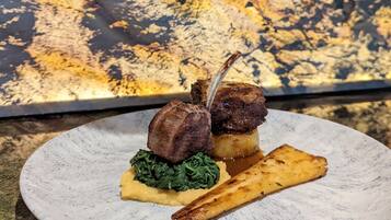 Une assiette contenant un morceau de viande, des légumes verts et une pomme de terre.