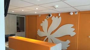 Una recepción con un gran motivo decorativo de hojas en la pared de fondo.