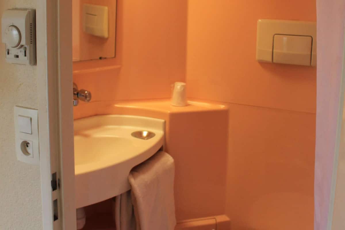 Ein kleines Badezimmer mit Toilette, Waschbecken und Spiegel.