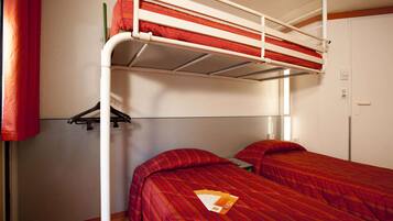 Habitación con literas, un armario y una pequeña mesa con un libro.