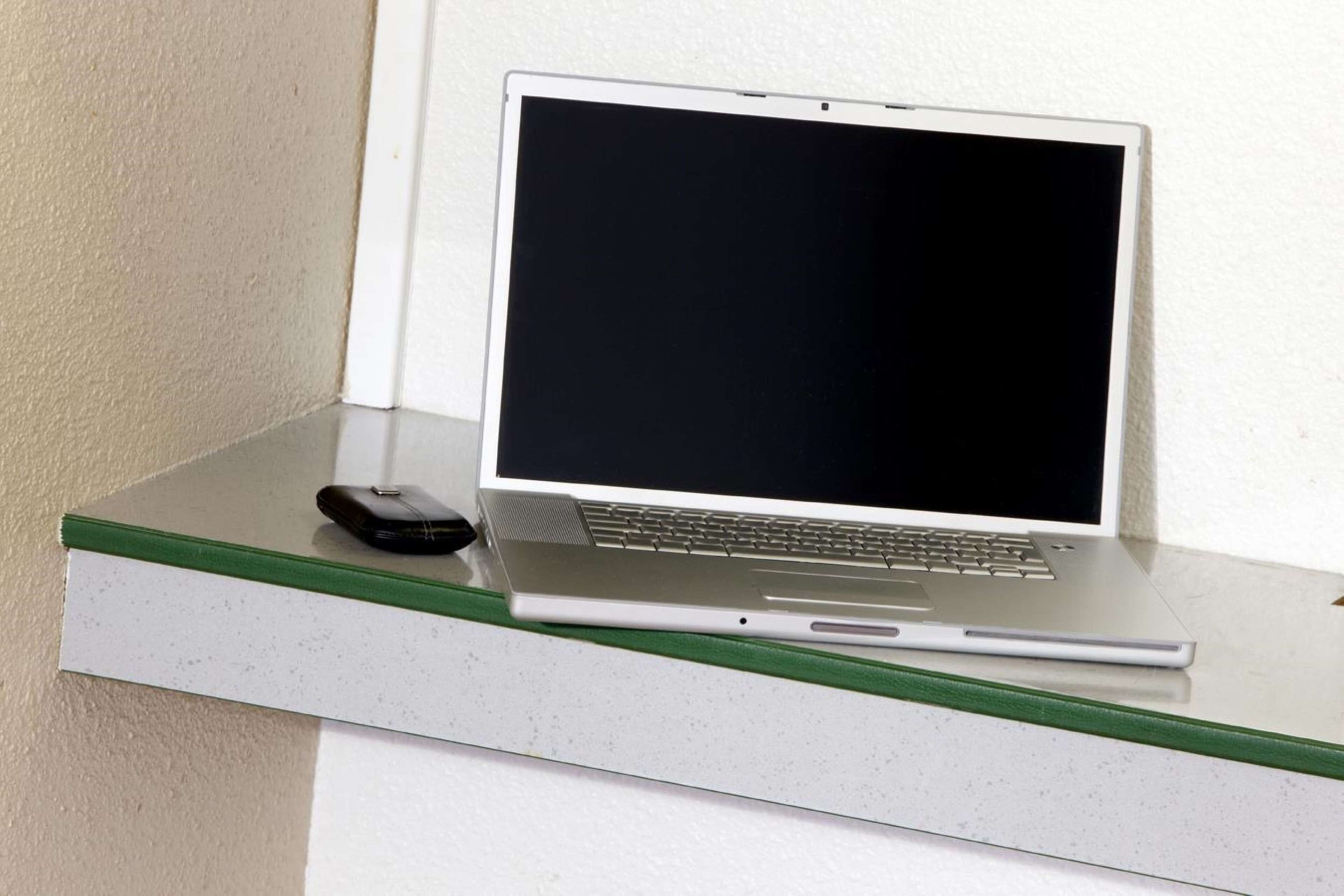 Un ordinateur portable posé sur un comptoir blanc, dont le bord est vert.