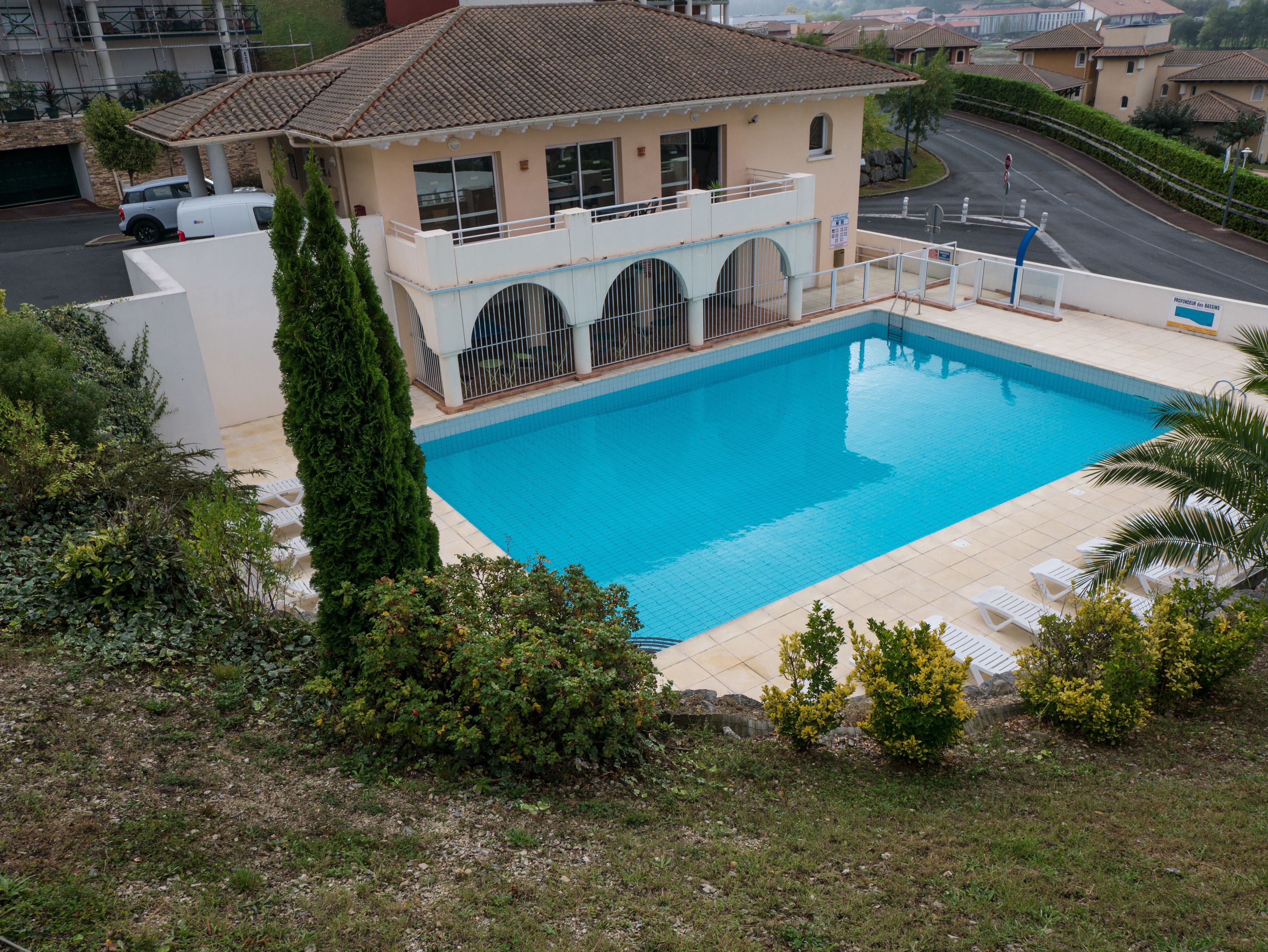 A swimming pool with a house in the background.