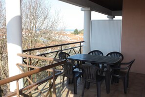 Un balcón con mesa y sillas, con vistas a una zona residencial.