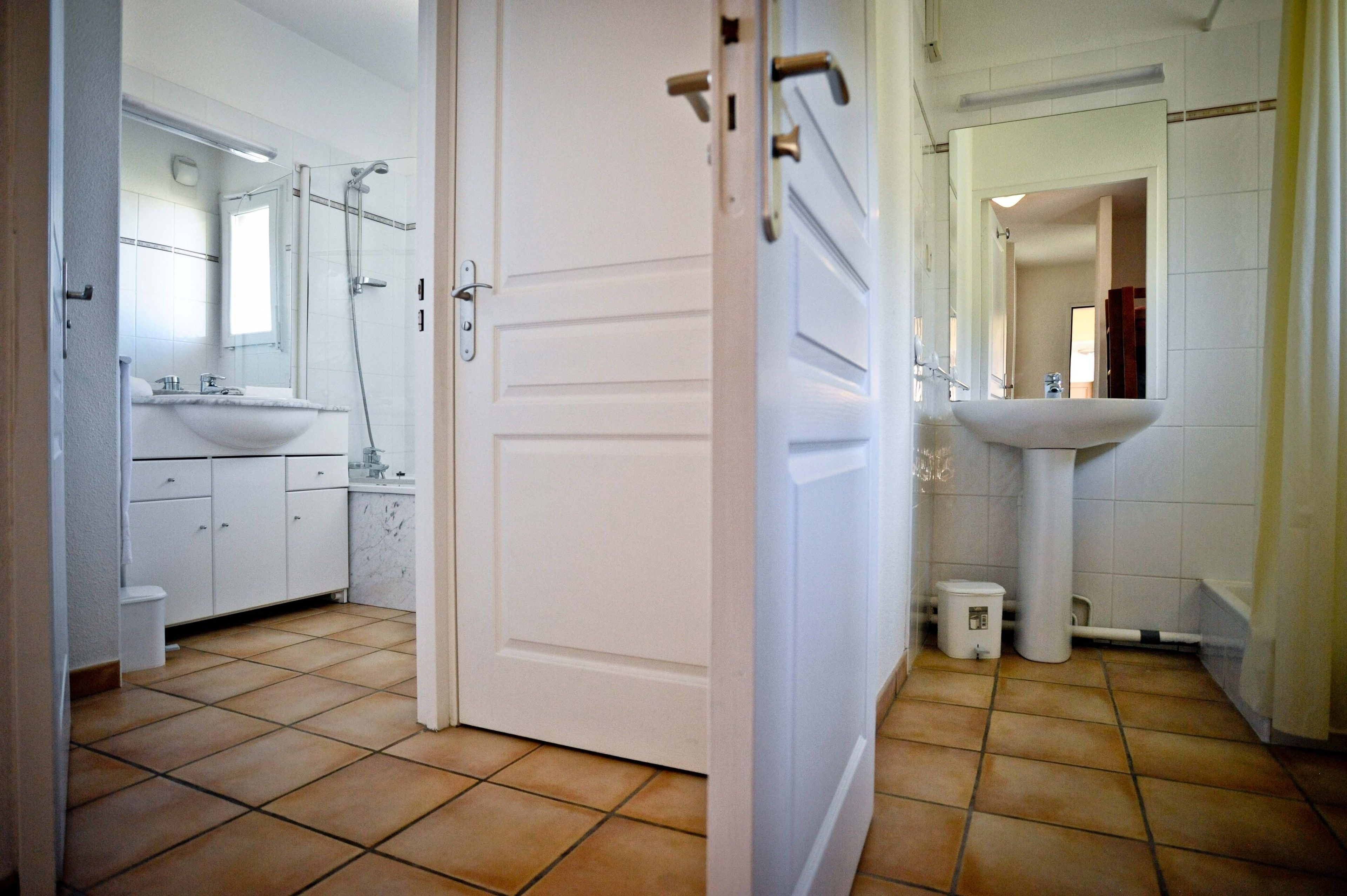 A bathroom with a white sink, a mirror, and a shower area.