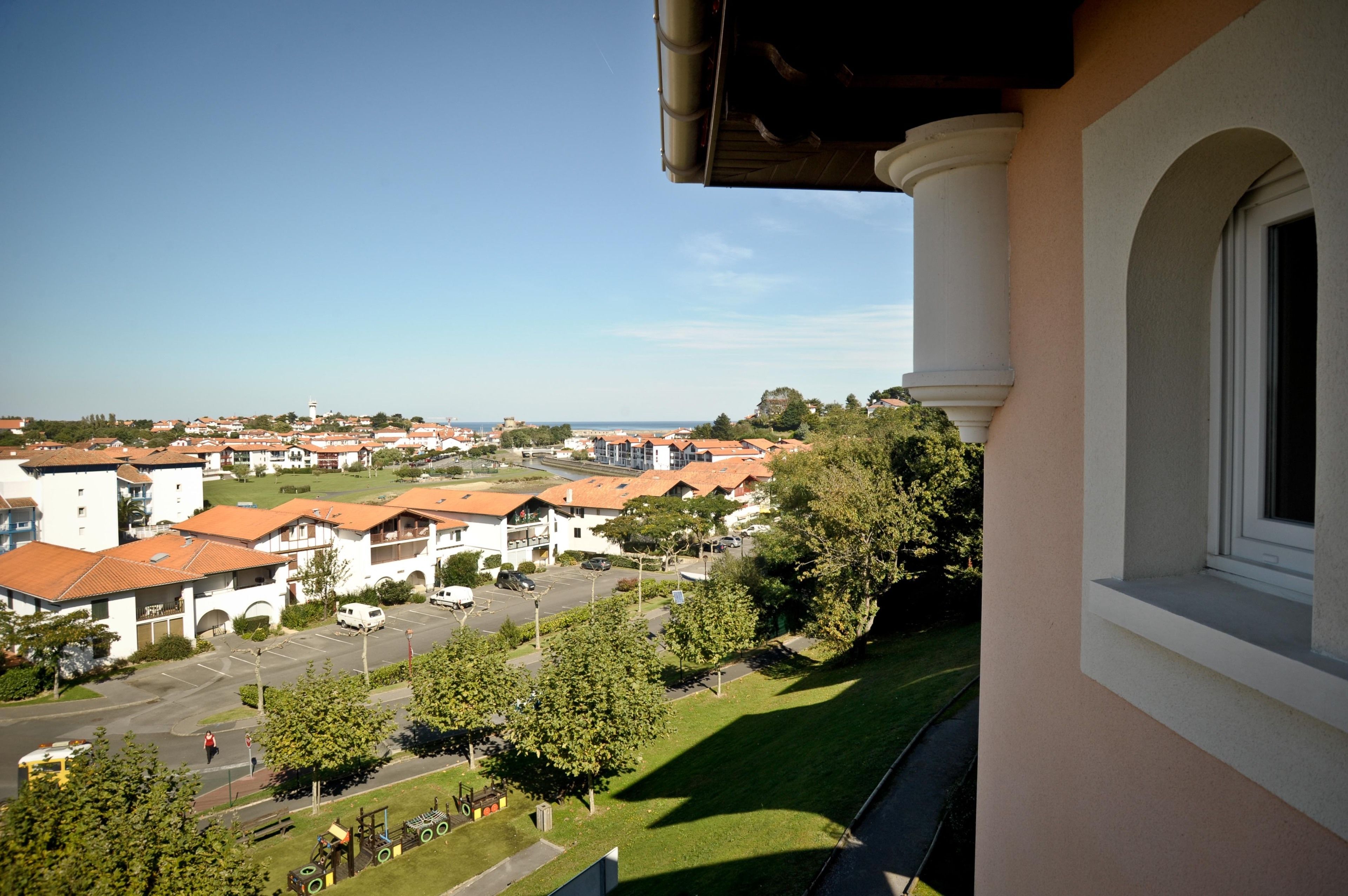 Zona residencial con vista a una calle, casas y una torre distante.