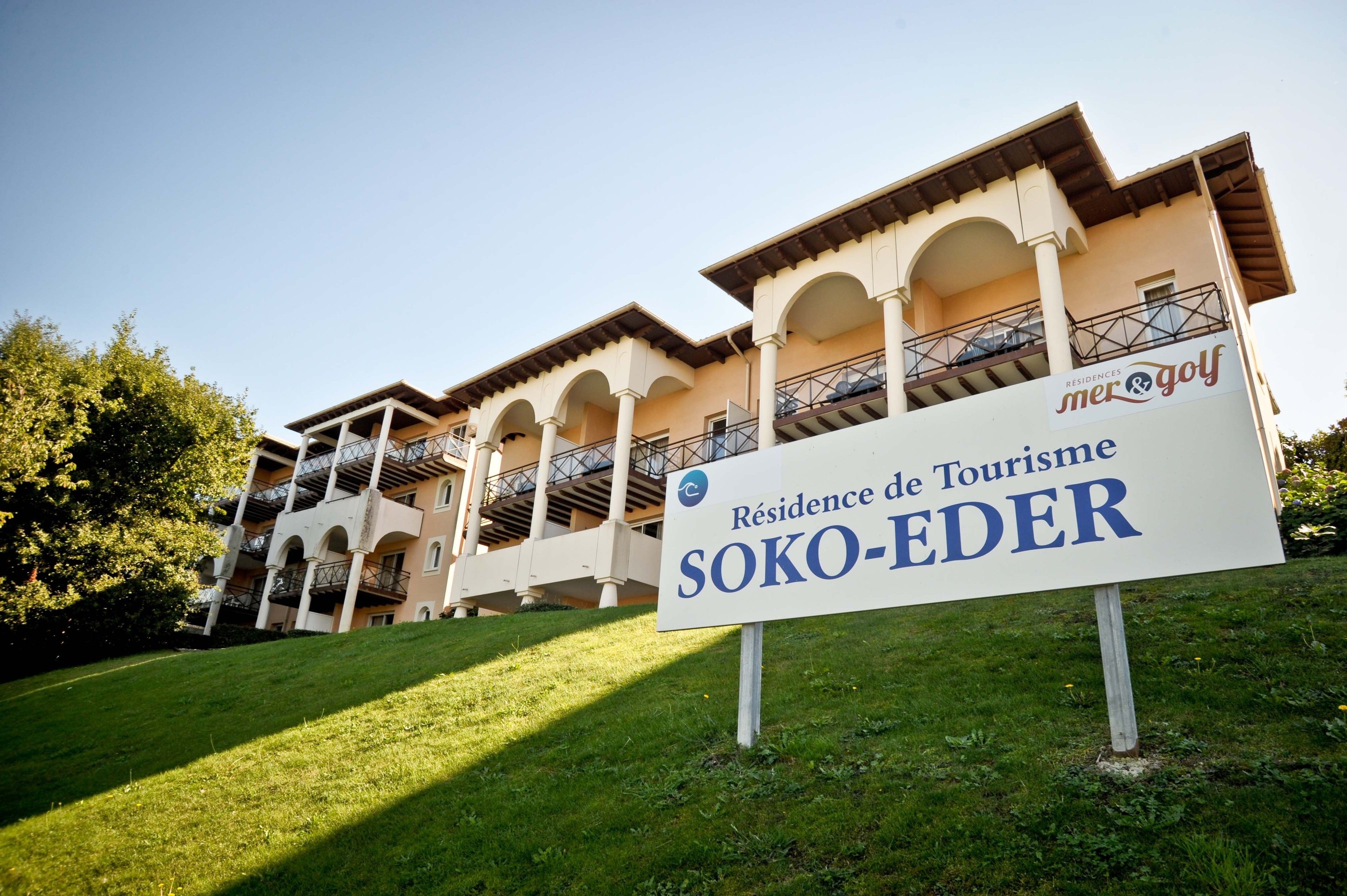 A hotel sign with "Residence de Tourisme Soko-Eder" and "mer&golf" branding.