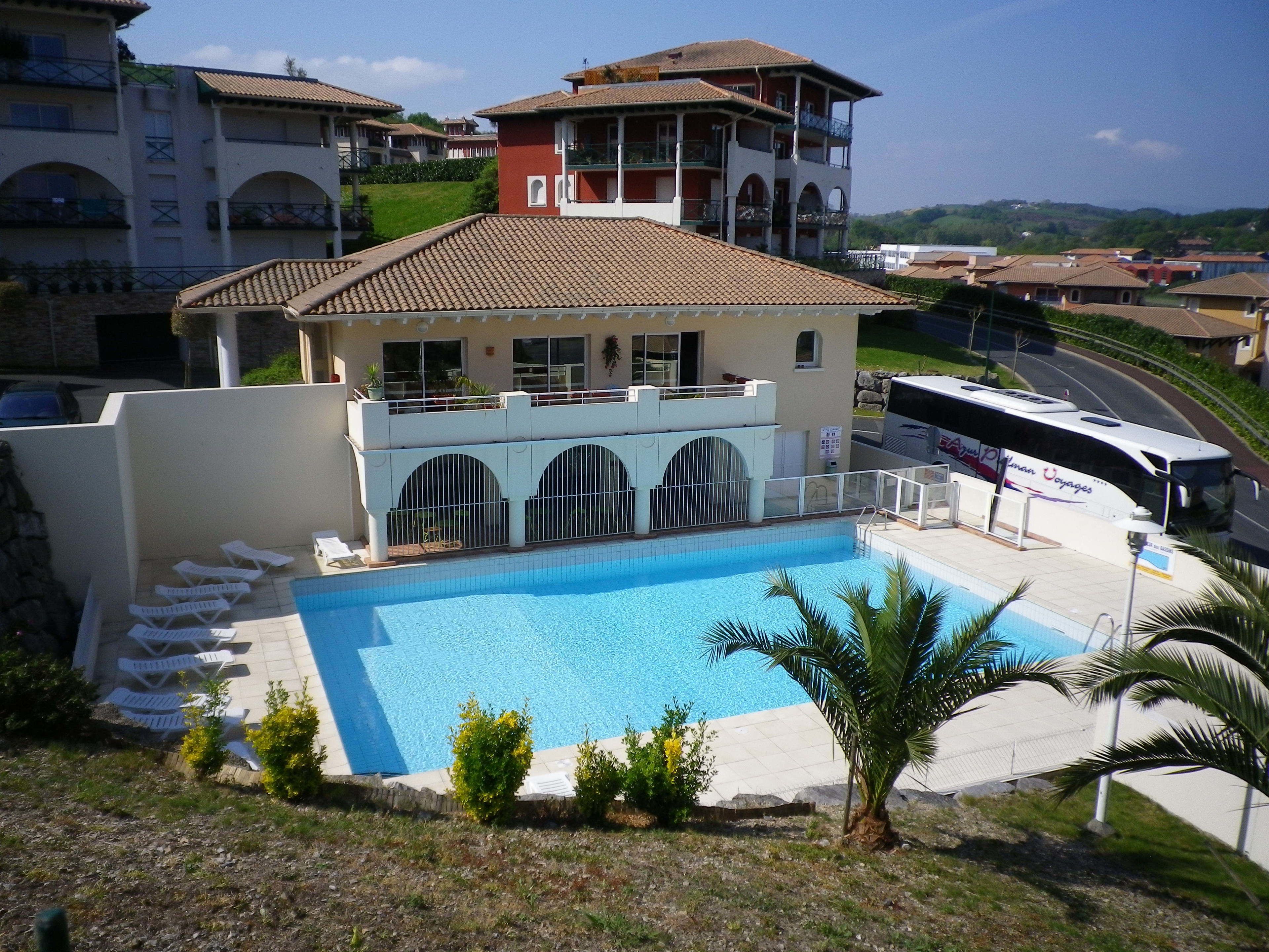 Un hotel con piscina, diversi balconi e vista sul territorio circostante.