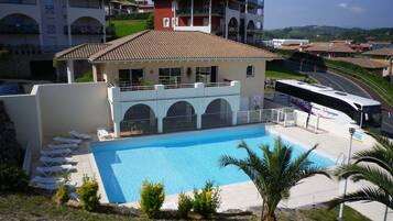Un hotel con piscina, diversi balconi e vista sul territorio circostante.