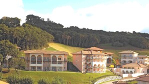 A hillside hotel with multiple buildings featuring balconies and arched windows. - Résidence Soko-Eder (Ciboure)