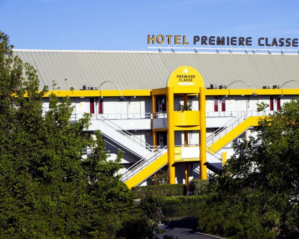 A hotel with a prominent yellow and white facade, multiple staircases, and a sign reading "HOTEL PREMIERE CLASSE". - Premiere Classe Beziers (Villeneuve-les-Beziers)