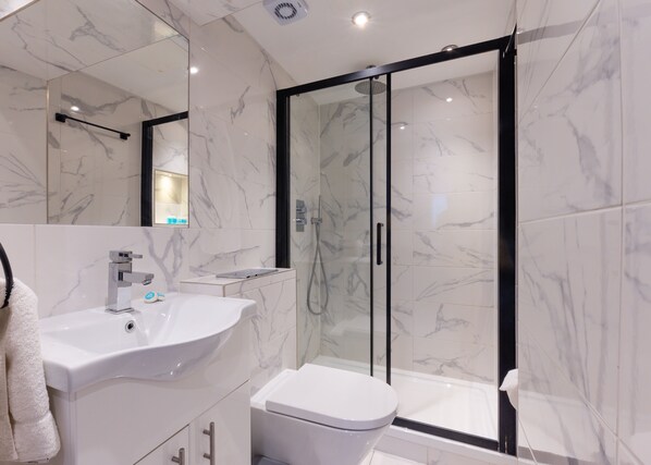 Luxe vierpersoonskamer, en-suite badkamer | Badkamer | Een douche, gratis toiletartikelen, een haardroger, pantoffels