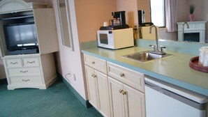 A compact kitchen with a microwave, coffee maker, and sink. - Meadow Court Inn (Ithaca)