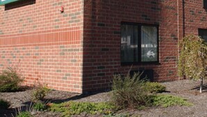 A brick building with a sign for Meadow Court Inn. - Meadow Court Inn (Ithaca)