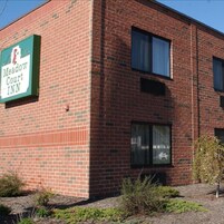 Un edificio de ladrillo con un letrero que indica Meadow Court Inn.