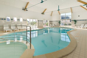 An indoor swimming pool with clear water, surrounded by sun loungers and a tiled floor. - Résidence Lagrange Vacances Les Jardins Renaissance (Azay-le-Rideau)
