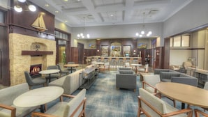 Um hall amplo com várias áreas de estar, uma lareira e um bar com temática náutica.