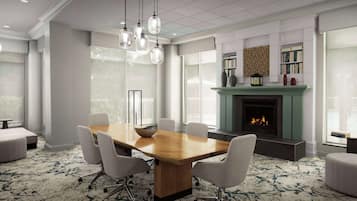 A conference room with a wooden table, six chairs, a fireplace, and large windows.