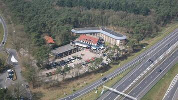 Vista aérea de un hotel con estacionamiento, una carretera y un puente.