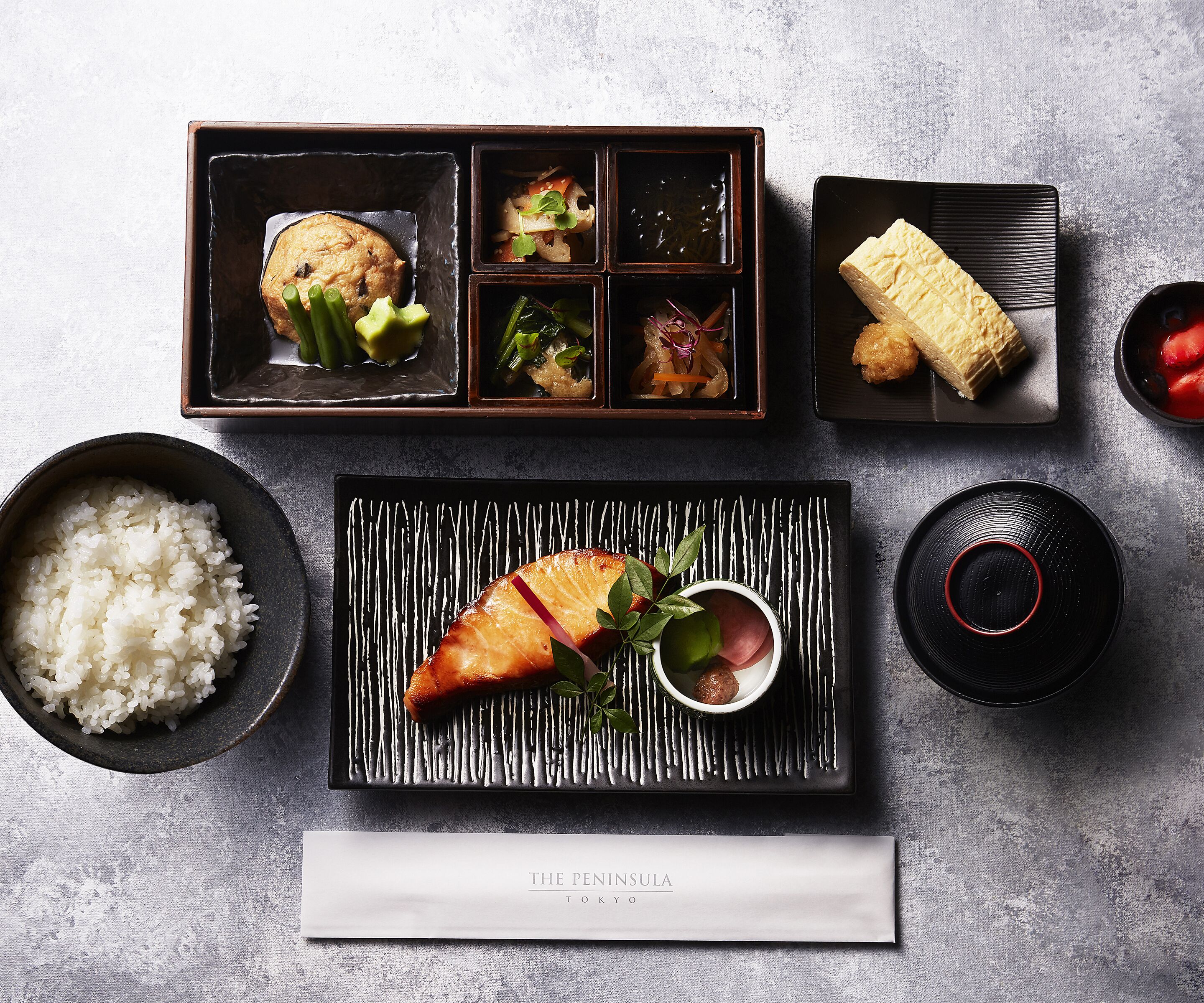 A traditional Japanese meal setup with rice, sashimi, and various side dishes.