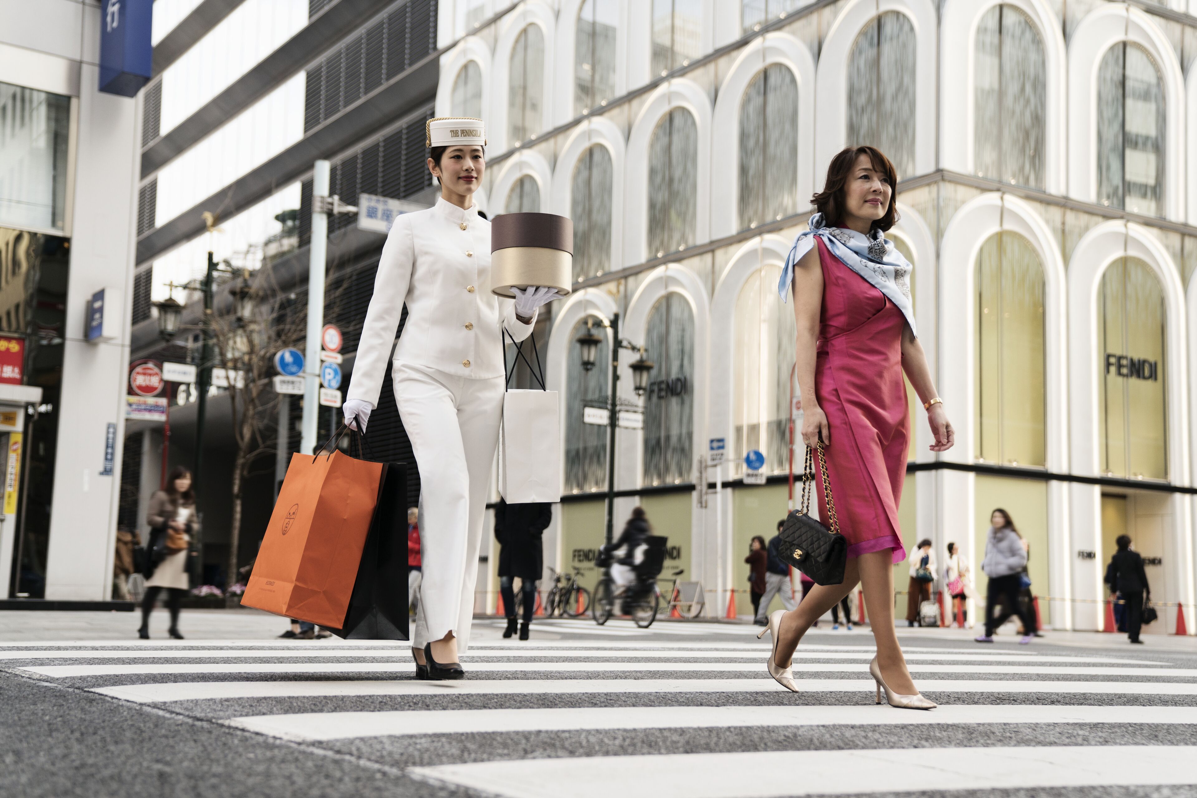 A street scene with pedestrians crossing a zebra crossing.