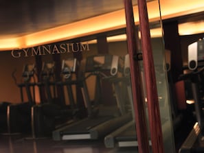 A gymnasium with exercise equipment, including treadmills and stationary bikes.