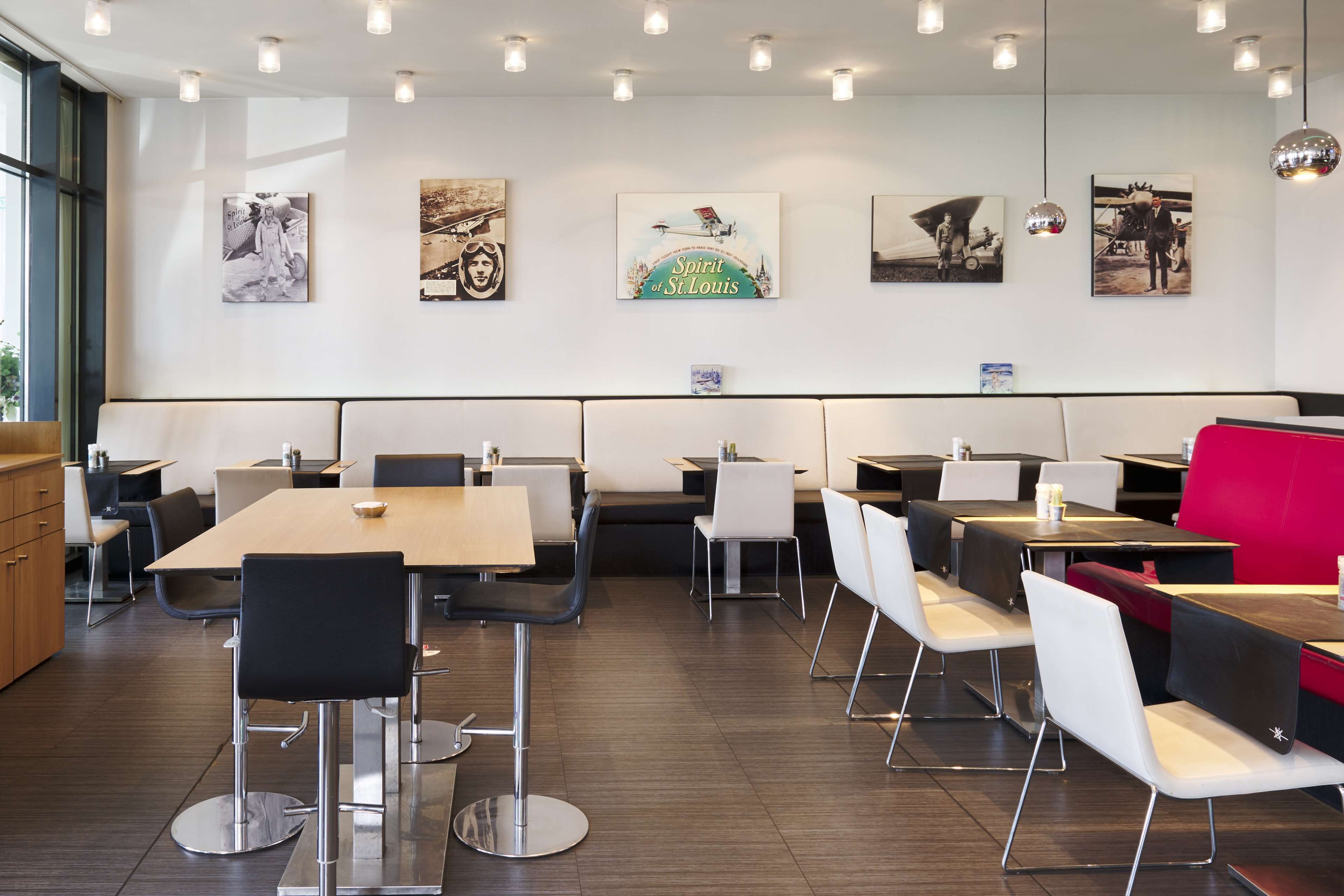 A modern restaurant with a variety of seating options, including booths and tables, and artwork on the walls.